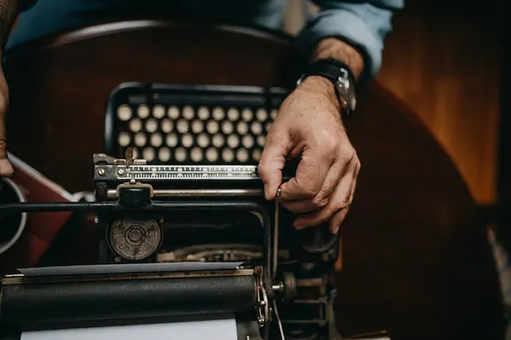 A man adjusting an old typewriter closeup