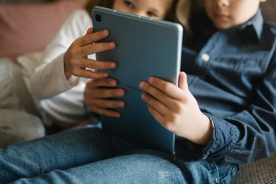 A boy and a girl looking at the tablet